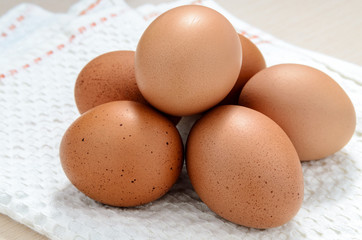 Brown chicken eggs on napkin.
