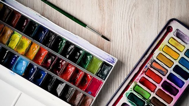 The artist is preparing to draw. Opens boxes, by the with watercolor paints eventually become addicted. Hands in the frame