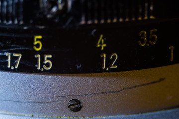 Old manual control lens body. Scratches and dirt. Close-up on the numbers of aperture ring