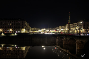 Fototapeta na wymiar Torino di notte, la città di torino si riflette nel fiume po in una fotografia a sfondo nero