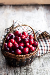 Fresh  cranberries in small wicker basket on wooden table