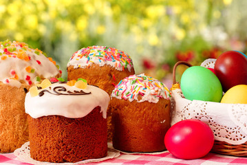 Easter. Cakes and colored eggs. Blurred background. Easter cupcakes and colorful eggs in a basket.