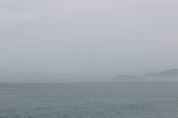 красивое море, в туманном облике, красивое голубое, синее, бриз на воде, горы в дали, мелькают в дымке весенней. 