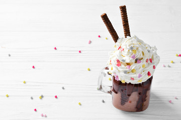 Chocolate milkshake with ice cream and with whipped cream, cookies, waffles, served in glass mason jar. 