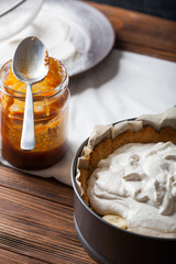 Moody Banoffee pie closeup with caramel in a mason jar on a wooden background