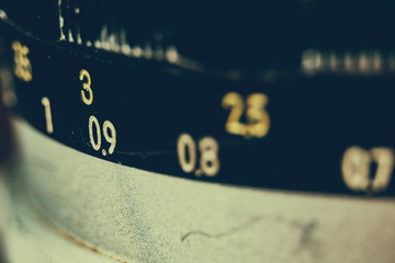 Old manual control lens body. Scratches and dirt. Close-up on the numbers of aperture ring. Retro style