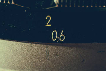 Old manual control lens body. Scratches and dirt. Close-up on the numbers of aperture ring. Retro style