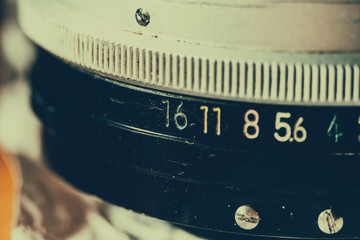 Old manual control lens body. Scratches and dirt. Close-up on the numbers of aperture ring. Retro style