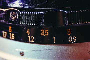 Old manual control lens body. Scratches and dirt. Close-up on the numbers of aperture ring. Concept of repair