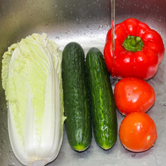 Washed vegetables. Vegetables under the running water in the sink. Fresh vegetables close-up.