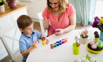 Obraz na płótnie Canvas Mother with kid painting easter eggs