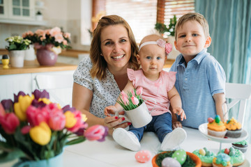 Fototapeta premium Happy easter. A mother and her kids painting Easter eggs