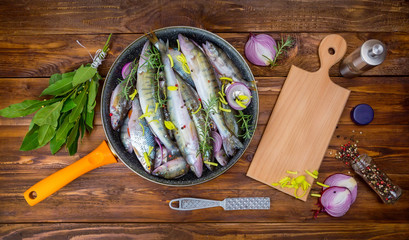 fresh fish perch in a saucepan with spices, top view. place for text
