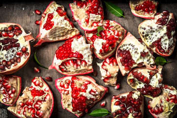 Fresh pomegranates on a wooden tray.