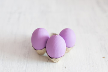 Easter postcard. Violet Easter eggs on a white vintage background. Copy space.