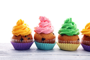 Tasty cupcakes on wooden background. Birthday cupcake in rainbow colors