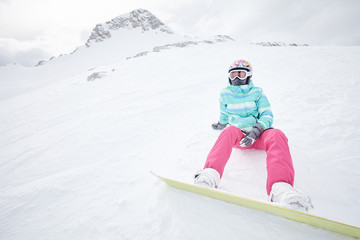Fototapeta na wymiar Young sitting woman with snowboard