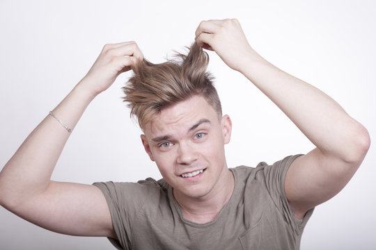 Jungem Mann stehen die Haare zu Berge, weil er sich in einer brenzlichen Situation befindet