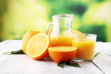 Glass of orange juice and slices of orange fruit on wooden background.