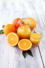 Glass of orange juice and slices of orange fruit on wooden background.