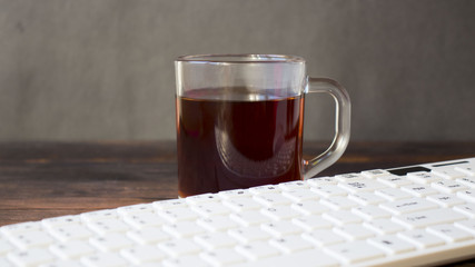 keyboards and a cup of tea on the table.