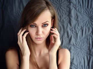 Fototapeta premium Portrait of a beautiful young woman with long hair looking at camera.