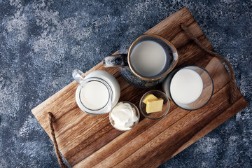 milk products - tasty healthy dairy products on a table sour cream in a bowl, cream and milk jar