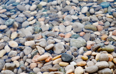 Texture of transparent crystal clear sea water and pebbles, summer sea water background