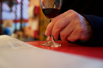 Man's hand holding glass of red wine - café, Paris