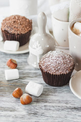 Cups with cacao and marshmallow, cupcakes and different decorations