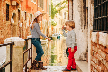 Two kids playing on the bridge in Venice. Little girl and boy visiting Venice, Italy. Small tourists in Europe © annanahabed