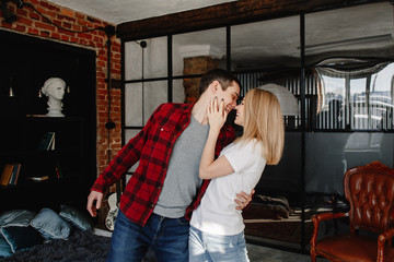 stylish young couple having fun in cozy bedroom in style loft,  feeling happy being together.