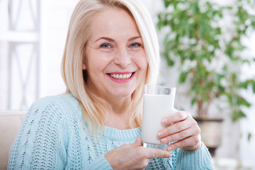 Happy middle aged woman drinking milk