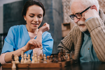 Nurse and senior man passionate about chess