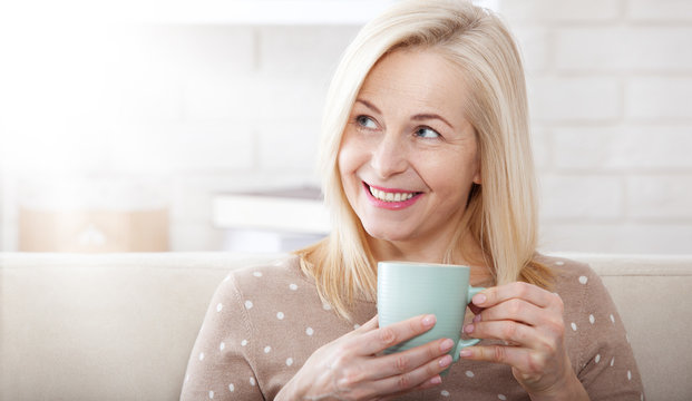 Portrait of happy blonde with mug in hands
