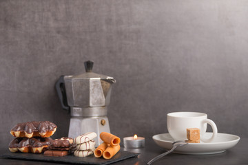 variety of biscuits on a table with coffee and flowers and candles