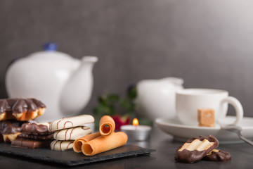 variety of biscuits on a table with coffee and flowers and candles