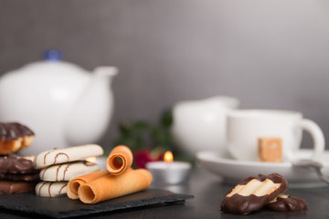 variety of biscuits on a table with coffee and flowers and candles