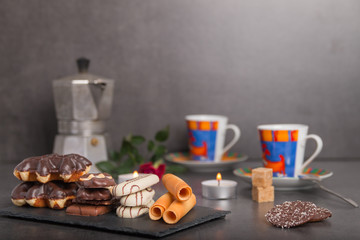 variety of biscuits on a table with coffee and flowers and candles