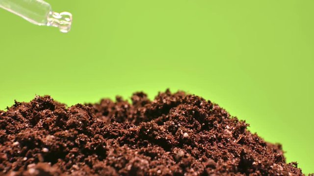 Soil close-up, laboratory research. A pipette with a solution. The soil rotates smoothly on a green background. Keying ready.