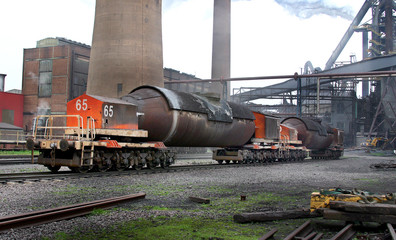 Hot liquid iron torpedo transfer rail cars near blast furnace.