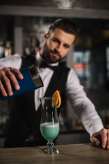 handsome bartender preparing alcohol cocktail