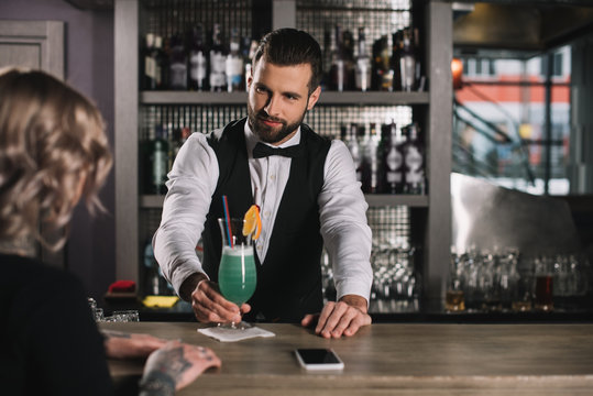 Handsome Bartender Giving Cocktail To Girl