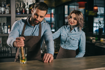 bartenders preparing alcohol drink at bar