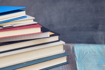 Geography lesson: Books on a black chalkboard, wooden table