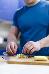 man cuts vegetables on a wooden lumber in the kitchen