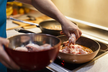 man who cooks Asian chicken wings at wok