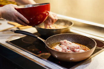man who cooks Asian chicken wings at wok