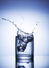 splash of water in the glass shot on light background with blue gradient
