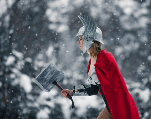 Woman in image of Germanic-Scandinavian God of thunder and storm goes with hammer in her hand....